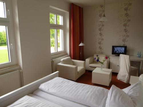 1 dormitorio con 1 cama y sala de estar en Hotel Adler, en Greifswald