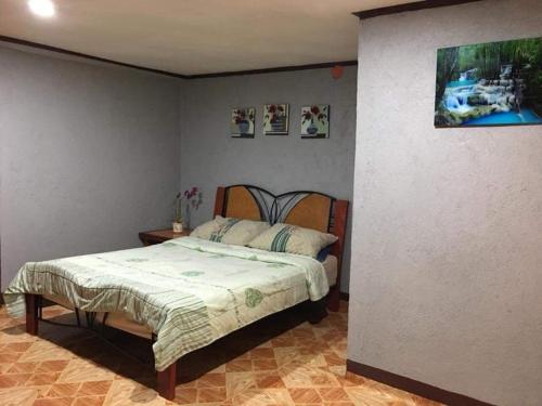 Pinoykano home في Candijay: غرفة نوم بسرير وجدار بالصور