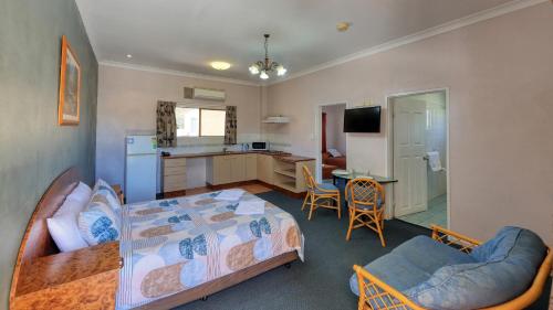 a bedroom with a bed and a kitchen at Townview Motel in Mount Isa