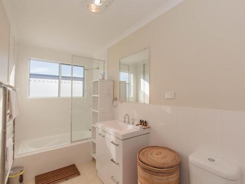 a white bathroom with a sink and a mirror at St Helenas 5 Twynam Street in Jindabyne