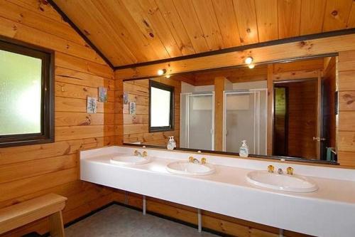 a bathroom with two sinks and a large mirror at Dakune Lodge in Ohakune