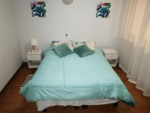 1 dormitorio con 1 cama con sábanas y almohadas azules en Departamento acogedor en centro de San Fernando en San Fernando