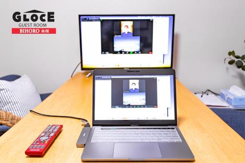 a laptop computer on a table with a remote control at GLOCE 美幌 ゲストルーム l BIHORO Guest room in Bihoro