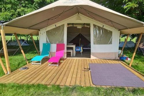 une tente avec des chaises, une table et un tapis de yoga dans l'établissement TENTE LODGE la Plage AUTET, à Autet