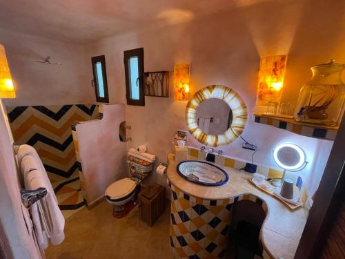 a bathroom with a toilet, sink, and mirror at Sueños Tulum in Tulum