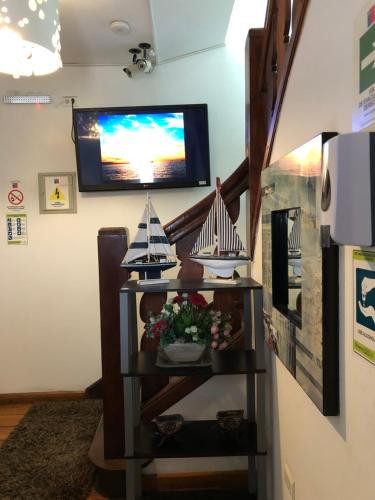 a room with a shelf with a tv on a wall at Hostal Magnolio in Viña del Mar