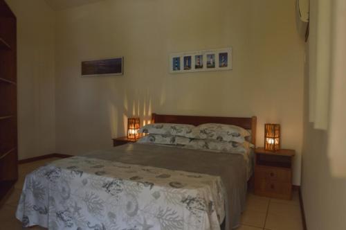 1 dormitorio con 1 cama y 2 mesitas de noche con luces en Residencial e Pousada com Piscina Farol 1245,10, en Florianópolis