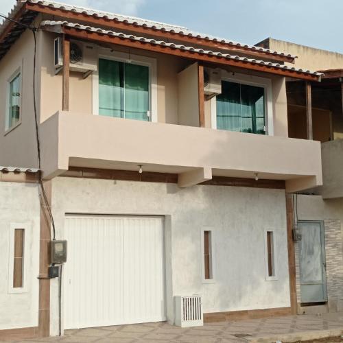 a house with a white garage door at Jockey Apto 1 in Campos dos Goytacazes