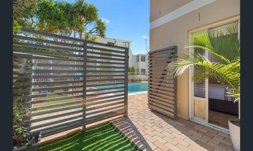 a privacy fence in front of a swimming pool at Aqua Promenade Beachfront Holiday Apartments in Sunrise Beach