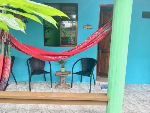 a room with two chairs and a red hammock at Boutique Rooms River Front at La Junta in Dominical