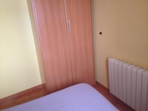 een slaapkamer met een deur en een radiator in een kamer bij Apartaments la Fabrica in Horta de San Joan