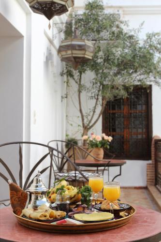 マラケシュにあるダール ワルダのテーブルの上に食べ物のトレイ(オレンジジュース2杯付)