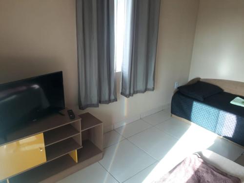a small room with a bed and a television at Apto Jockey 4 in Campos dos Goytacazes