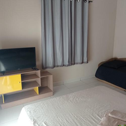 a bedroom with a bed and a tv and a window at Apto Jockey 4 in Campos dos Goytacazes
