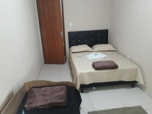 a small bedroom with two beds and a door at Apto Jockey 3 in Campos dos Goytacazes