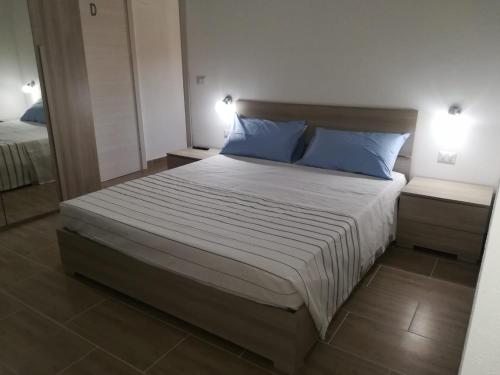 a bedroom with a large bed with blue pillows at Affittacamere Sos Ninnitteddos in Torpè