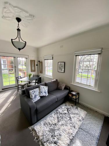 a living room with a couch and a table at East Melbourne City Studio - Amazing Location & Sunny Charm in Melbourne