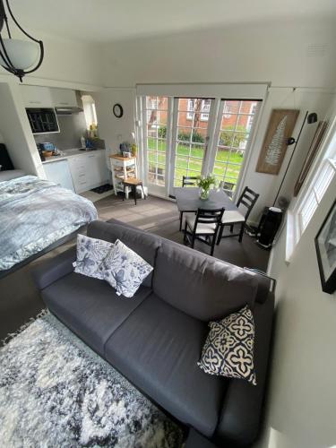 a living room with a couch and a bedroom at East Melbourne City Studio - Amazing Location & Sunny Charm in Melbourne