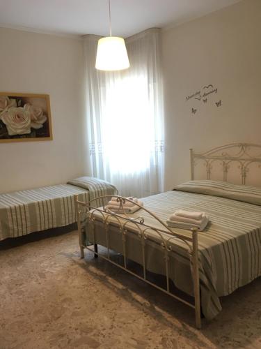 1 dormitorio con 2 camas y ventana en B&B Al Campanile, en Taranto