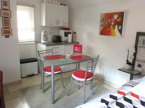 a small kitchen with a table and two chairs at La Cour des Amis in Vendenheim