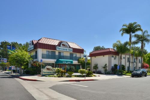 a building with a car parked in front of a street at Tarzana Inn in Tarzana
