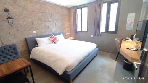 a bedroom with a bed with a british flag pillow at 沐谷親子溫泉會館 in Jiaoxi