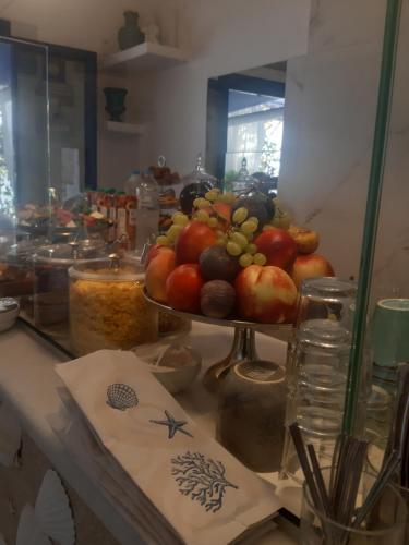 a table with a plate of fruit on a counter at Doron Hotel Delfini in Naxos Chora