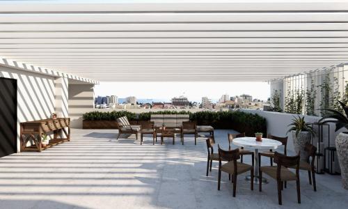 a patio with tables and chairs on a roof at Alinea Urban Saripolou Square in Limassol