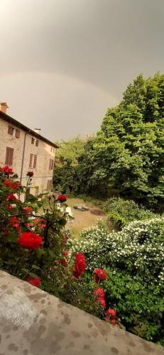 - une vue sur un jardin avec des fleurs rouges et un bâtiment dans l'établissement Relaxing Retreat in Rural Italy B&;B, à Maranello