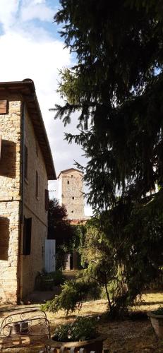 un bâtiment avec un arbre à côté d'un bâtiment avec une tour d'horloge dans l'établissement Relaxing Retreat in Rural Italy B&;B, à Maranello