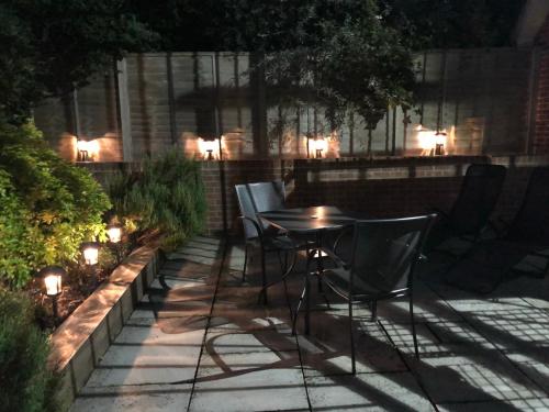 a table and chairs in a garden at night at Idyllic Studio Flat in Winchester