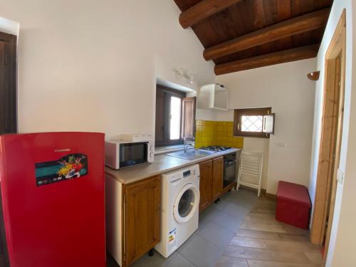 eine Küche mit einem roten Kühlschrank und einer Waschmaschine in der Unterkunft Monolocale Sant'Andrea in Palermo
