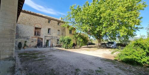 a building with a tree and a car parked next to it at Studio 2 Personnes avec piscine in Jonquières