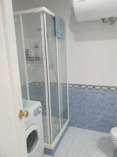 ein Badezimmer mit einer Dusche und einer Waschmaschine in der Unterkunft Apartamento en Isla Cristina Puerto Deportivo in Isla Cristina