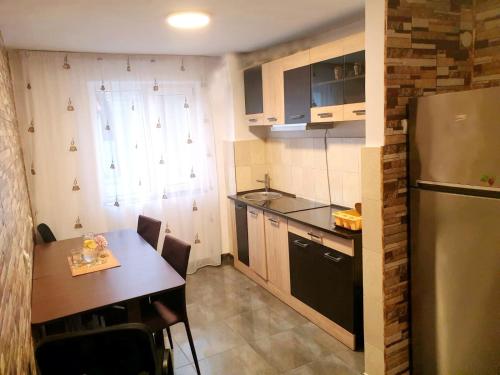 eine kleine Küche mit einem Tisch und einem Kühlschrank in der Unterkunft Apartament Dor de Delta Sulina in Sulina