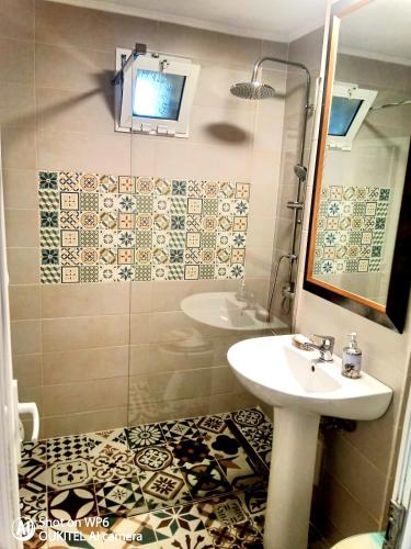 a bathroom with a sink and a mirror and a shower at Apartament Dor de Delta Sulina in Sulina