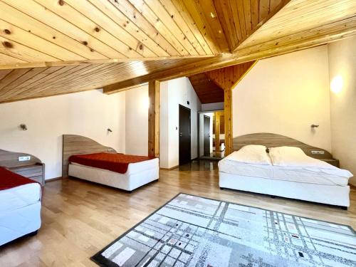 a bedroom with two beds and a wooden ceiling at Комплекс Орлово гнездо in Beli Iskar