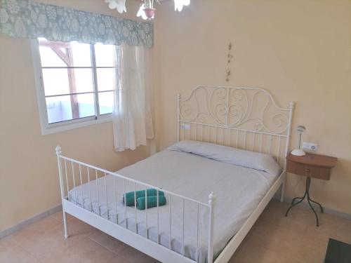 a small bedroom with a white bed and a window at Casa Gaia in Las Playitas