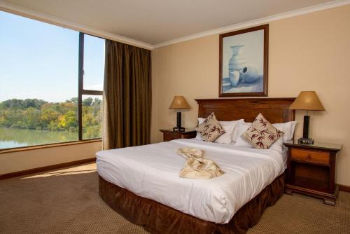 a hotel room with a bed with a dog on it at Riviera on Vaal Resort in Vereeniging