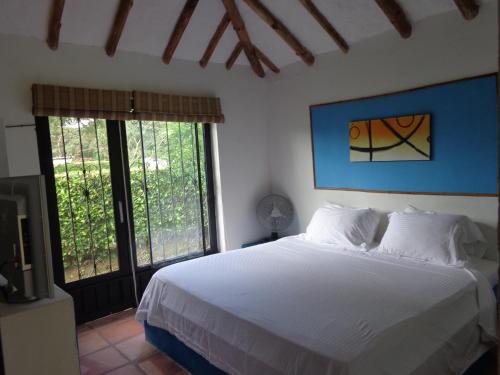 A bed or beds in a room at Hotel Campestre Arboretto