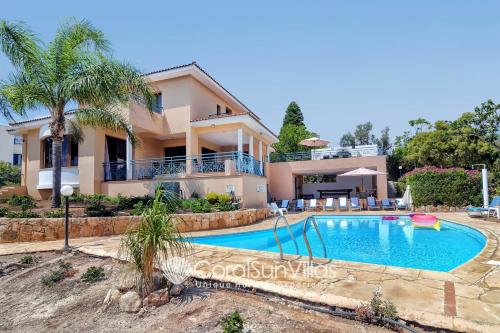 a villa with a swimming pool and a house at Zeus Sublime Villa 5 bedrms HEATED POOL by Coral Sun Villas, in Coral Bay