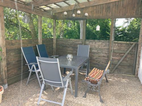 a patio with a table and chairs in a shed at Haus Wald und Wiese Wohnung Wald in Ehndorf