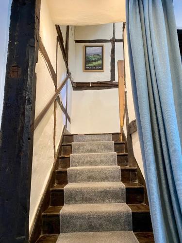a staircase in a house with a blue curtain at Number 22, Castle Street in Hay-on-Wye