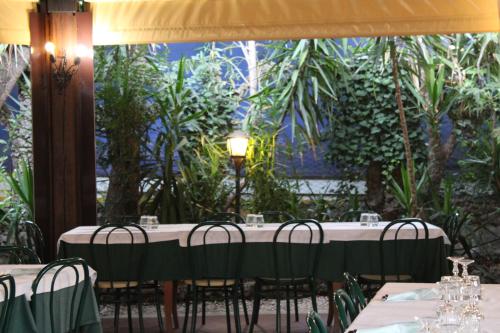 a table with chairs in front of a large window at Hotel La Locanda Del Borgo in Casal Monastero