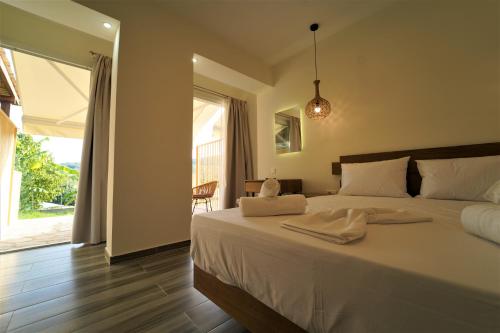 a bedroom with a bed with white sheets and a window at Casa Arkoudas in Parga