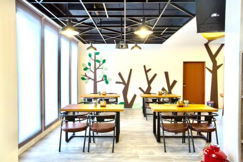 a restaurant with yellow tables and chairs and windows at 河沿悅舍ZW朋友同學聚會推薦l獎勵旅遊宜蘭包棟l家庭親子民宿l烤肉麻將浴缸戲水池 in Zhuangwei
