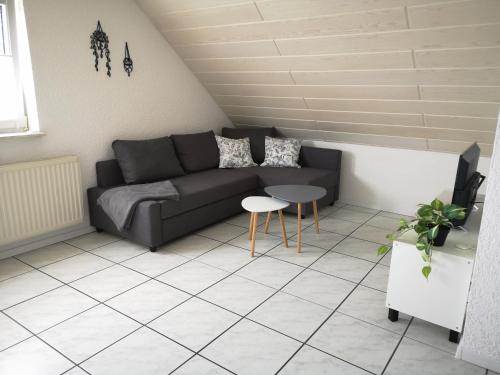 ein Wohnzimmer mit einem Sofa und einem Tisch in der Unterkunft Familienfreundliche Ferienwohnung mit Wohlfühlbalkon und kostenlosem Parkplatz nahe Messe und Bodensee in Meckenbeuren