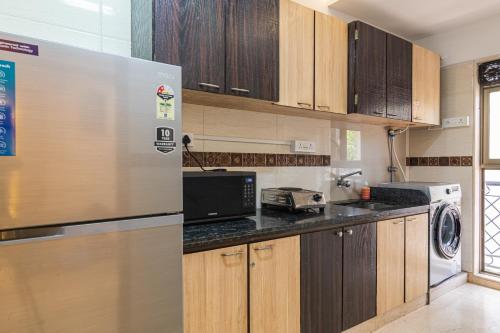 a kitchen with wooden cabinets and a refrigerator at OSI Apartments Carter's Road Bandra West in Mumbai