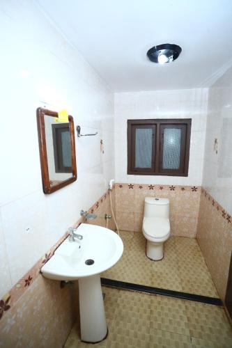 a bathroom with a sink and a toilet at Beach Paradise Day Cruise Houseboat in Alleppey