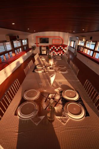 a long table with plates and dishes on a boat at Beach Paradise Day Cruise Houseboat in Alleppey